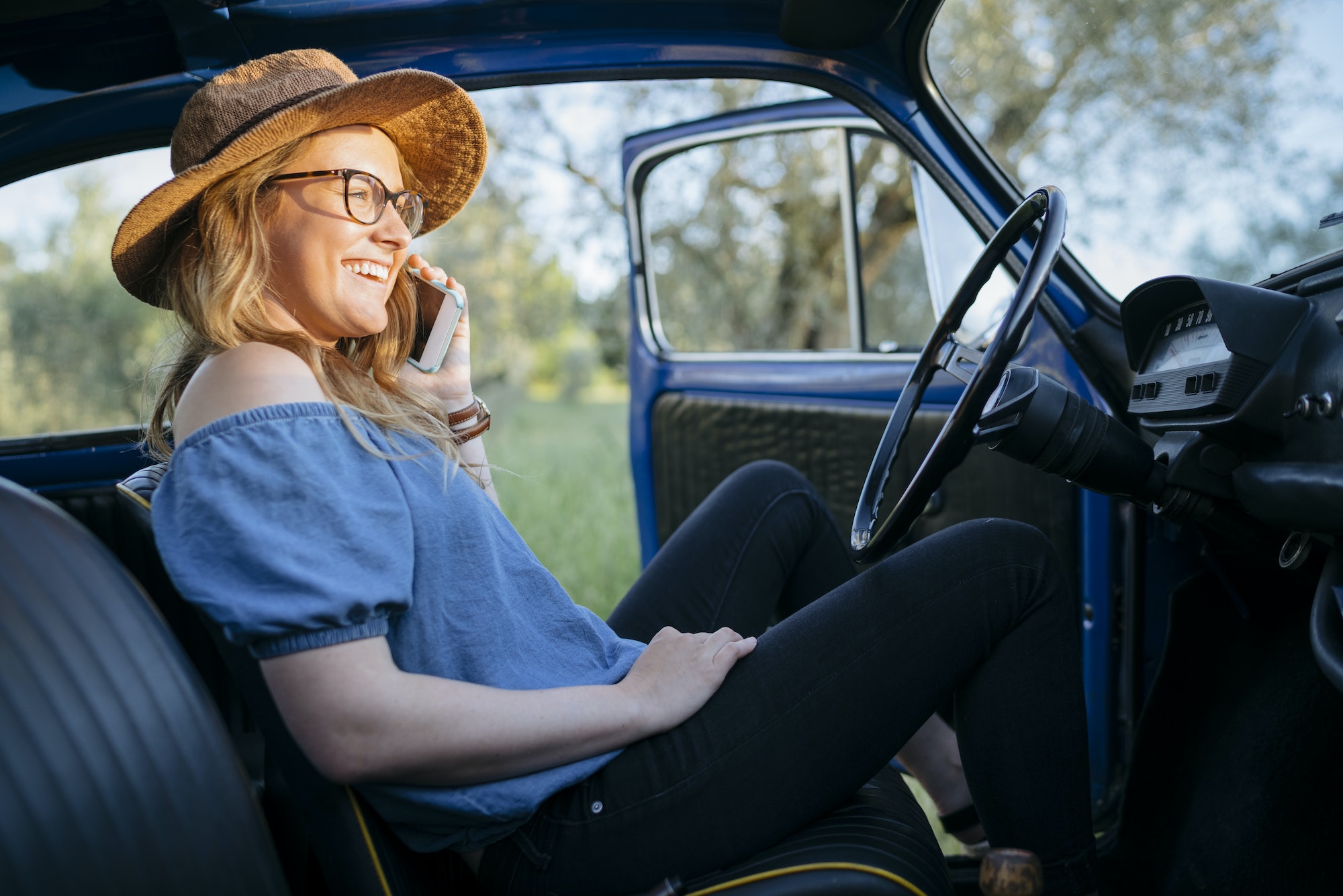 Woman in car using smartphone smiling, Firenze, Toscana, Italy, Europe