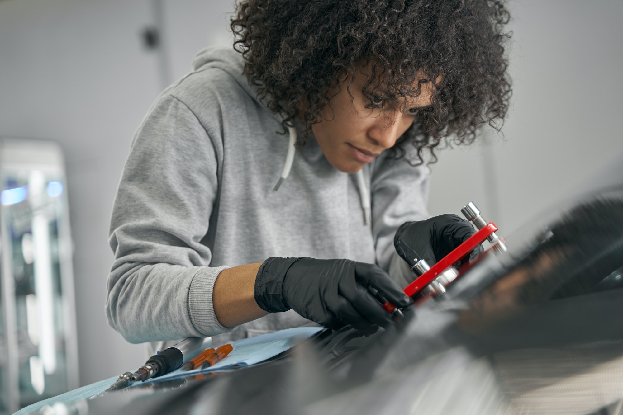 Worker installing windscreen bridge on auto glass